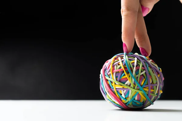 Woman hand with colorful rubber bands ball