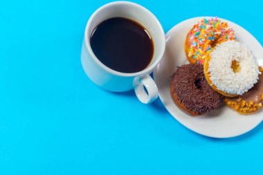 fincan kahve ve çörek üzerinde mavi arka plan izole