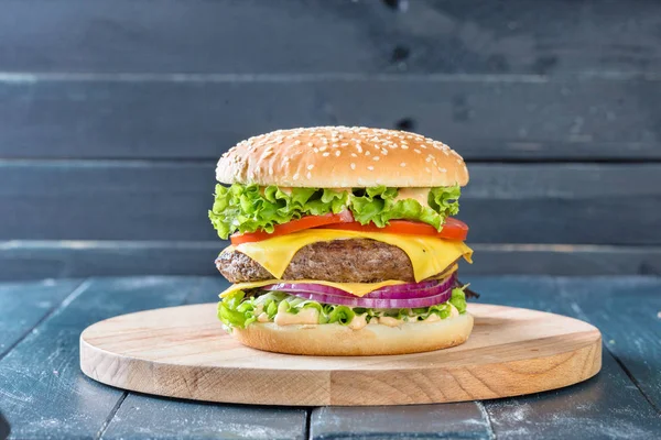 Ahşap tahta üzerinde büyük sulu hamburger 