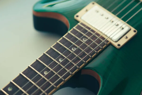 Electric guitar body and neck detail on wooden background