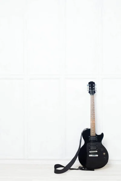 吉他支撑在白色墙壁前面 — 图库照片