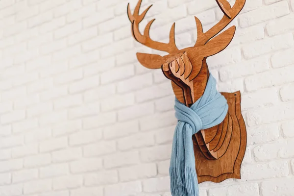 Decorative wooden Christmas elk with a scarf in interior