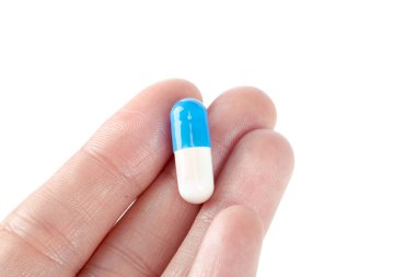 Beyaz arka plan üzerinde izole hap tutan el yakın çekim 