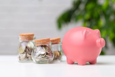 Masanın üzerinde para olan kumbara.