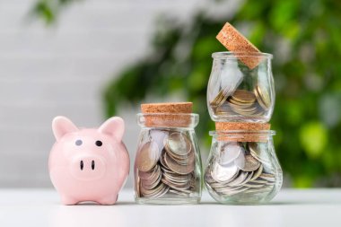 Masanın üzerinde para olan kumbara.