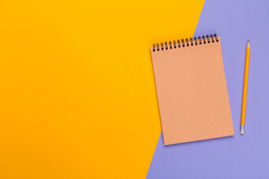 Tasarımınızın üstten görünüm parlak bicolor arka plan üzerinde boş kağıt Not defteri