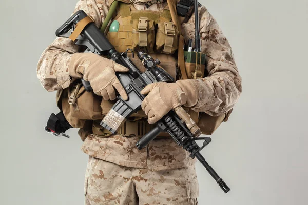 Kamuflajlı asker elinde tüfekle