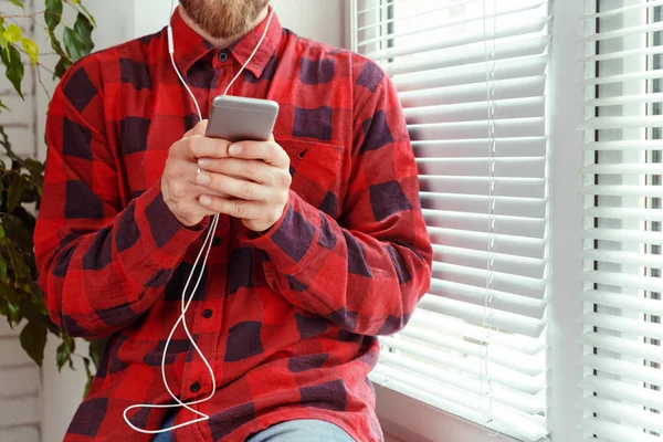 Beau Jeune Homme Dans Les Écouteurs Tenant Téléphone Mobile — Photo