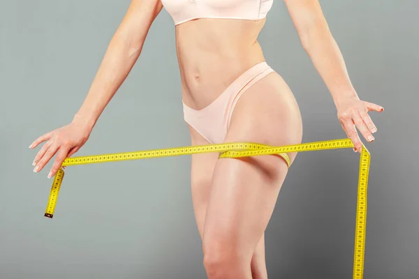 Healthy female body with measuring tape