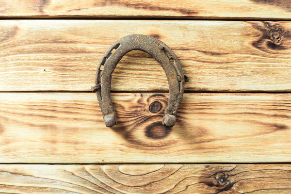 old rusty horseshoes on wooden board
