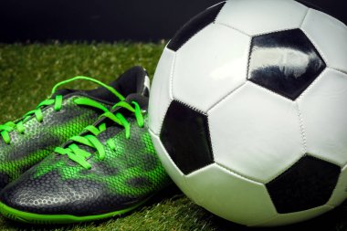 Futbol topu ve ayakkabısı futbol sahasına