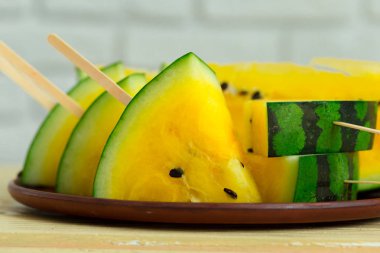 Ahşap arka plan üzerinde sarı dilim karpuz