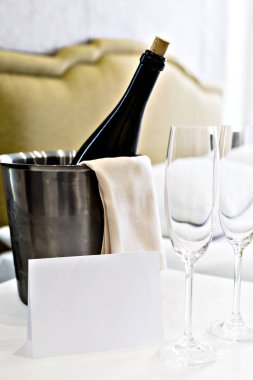 Balayı konsepti. Bir otel odasında yatağın yanında şampanya kovası