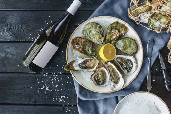 Open wet oysters on a plate with lemon, close-up view