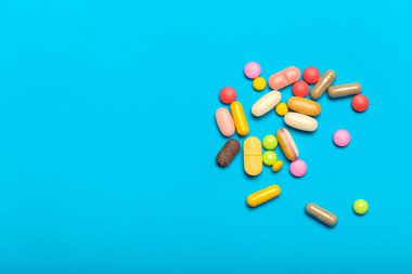 Mavi bir arka plan üzerinde hap saçılmış