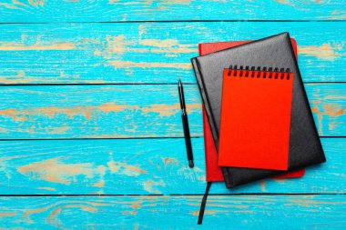 Üstten görünüm çalışma alanıyla boş defter ve kalem ahşap masa arka plan üzerinde