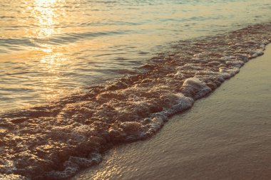 Sahilde deniz batımı olan manzara