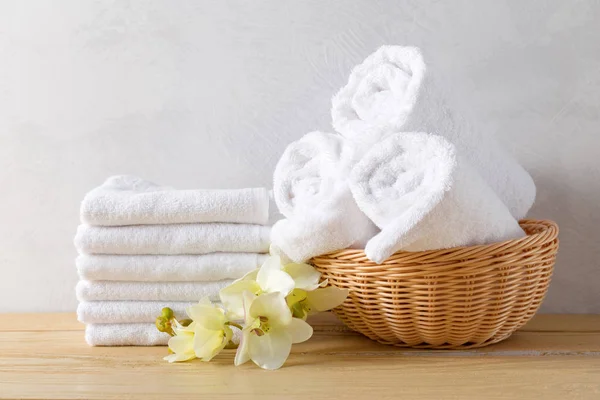 towels roll with flowers on wooden table