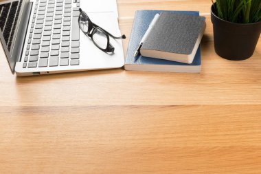 Not defteri ve ahşap masa üstünde laptop