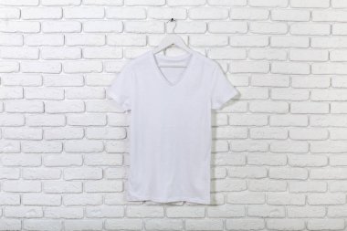 t-shirt ile tuğla badanalı duvara askı