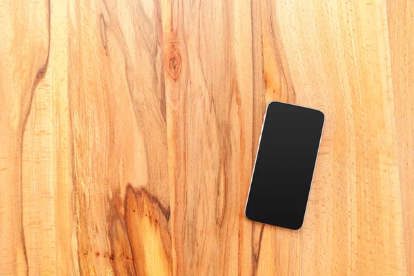 Mobile phone with blank screen mockup on wood table background