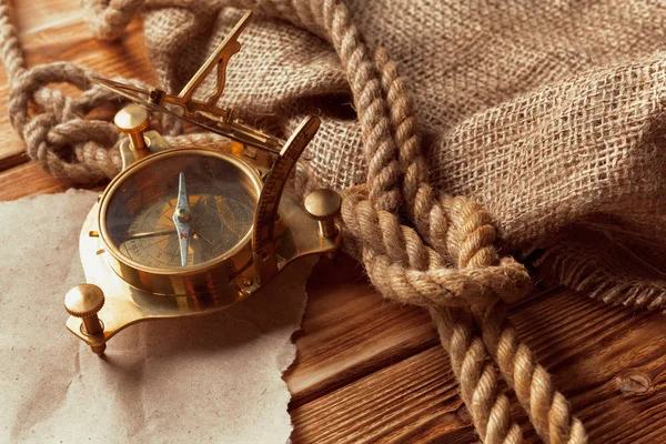 compass and rope on old wooden boards