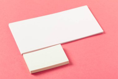Pembe renkli bir arka plan üzerinde boş kağıt parçaları