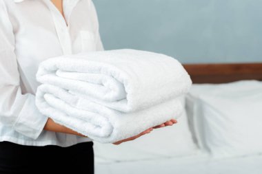 Hizmetçi bir otel odasında temizlik sırasında temiz temiz havlu ile