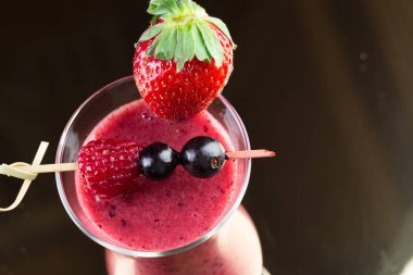 Koyu arka plan üzerinde çilek güler yüzlü