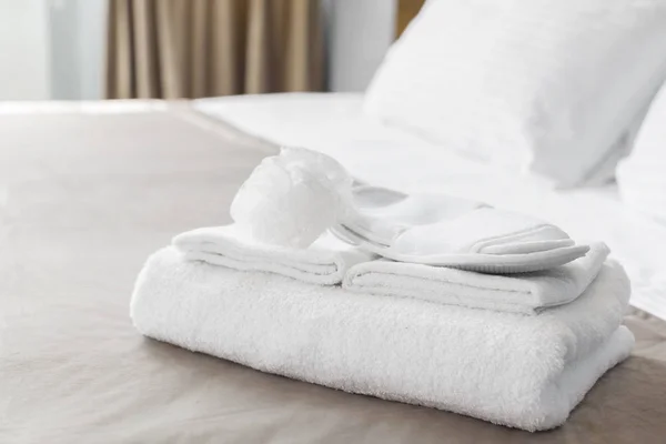 White towels on bed in guest room for hotel customer