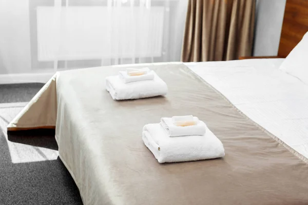 White towels on bed in guest room for hotel customer