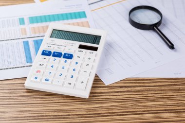 Büyüteç, hesap makinesi ve kağıtları çalışma