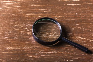 Ahşap arka plan üzerinde büyüteç