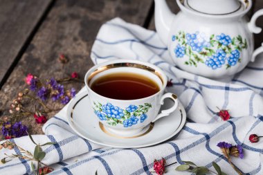 Natürmort çay bardağı ve ahşap masa üzerinde masa örtüsü