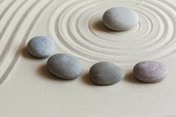 zen meditation stones on sandy background