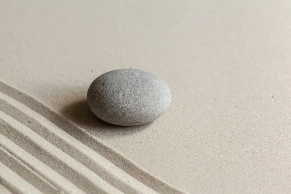 zen meditation stone on sandy background