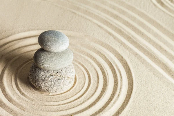 zen meditation stones on sandy background
