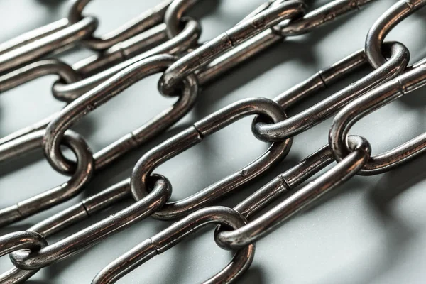 close up of metal chains on light background