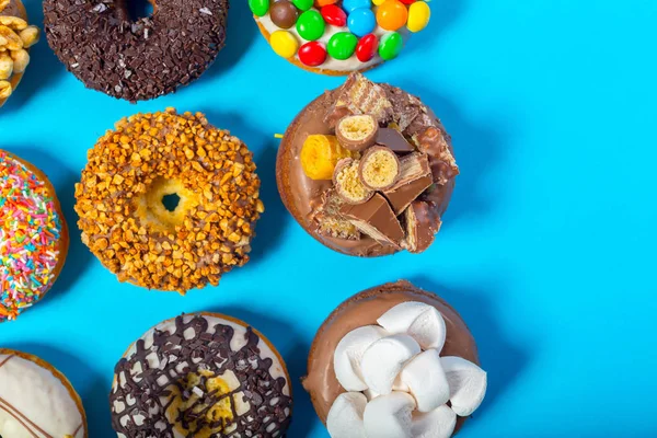 Verschiedene Donuts Auf Blauem Hintergrund — Stockfoto