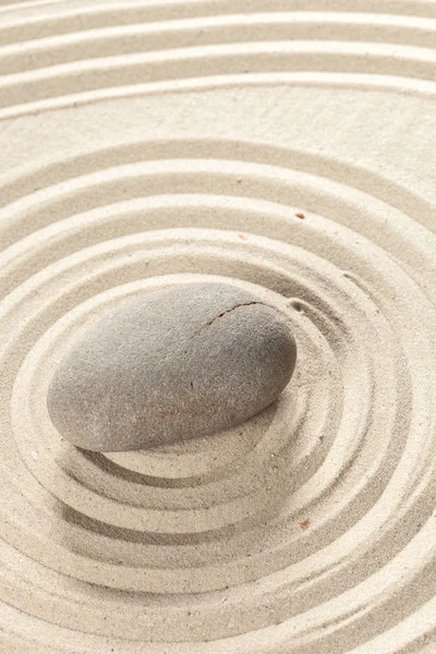 zen meditation stone on sandy background