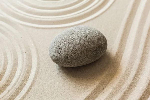 zen meditation stone on sandy background