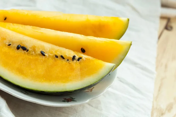 Yellow watermelon sliced on wooden background