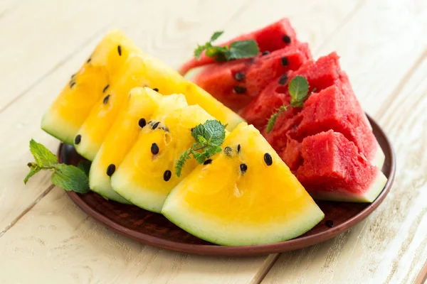 Yellow watermelon sliced on wooden background