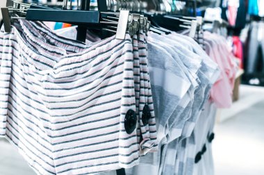 Askılarda farklı giysiler. Kapatın.