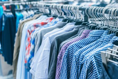 Askılarda farklı giysiler. Kapatın.