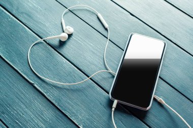 smartphone ahşap zemin üzerinde bağlı beyaz kulaklık