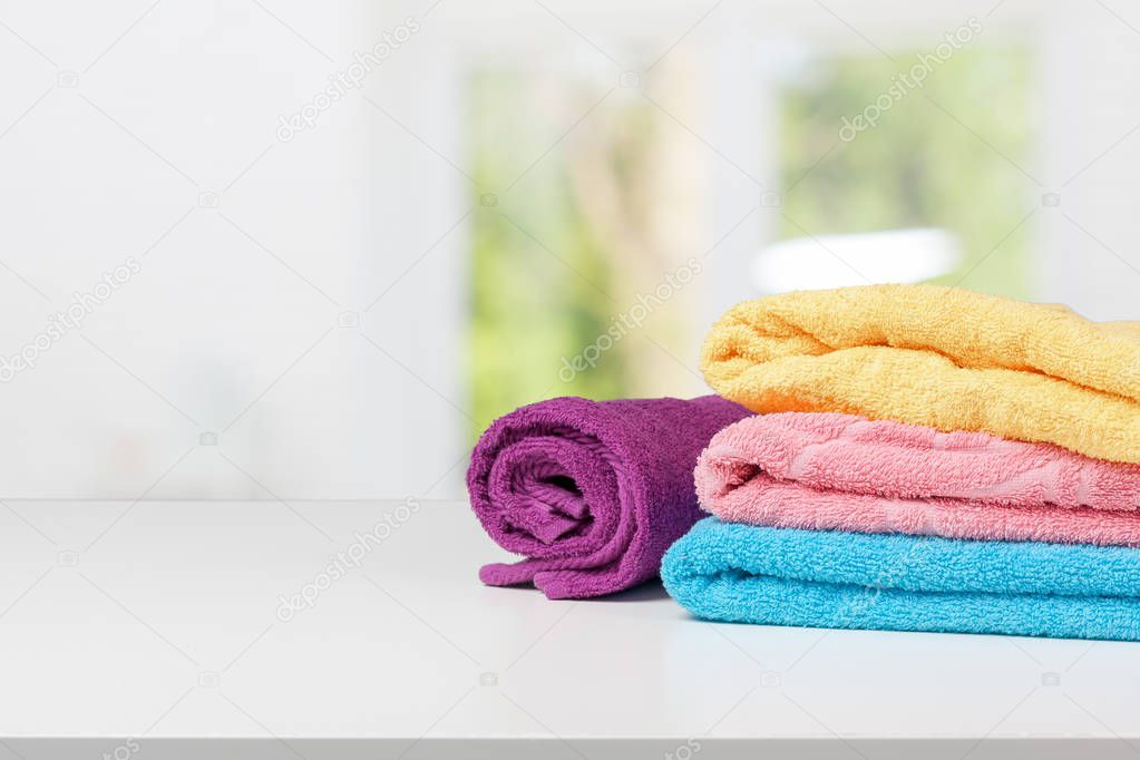 Stack of bath towels on light white background closeup