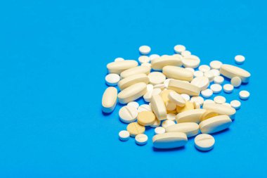 Mavi bir arka plan üzerinde hap saçılmış