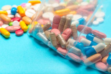 Mavi bir arka plan üzerinde hap saçılmış