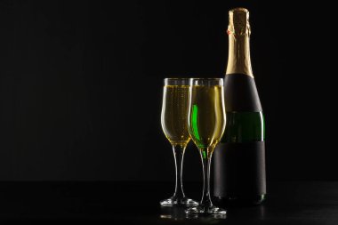 Şampanya şarap kadehi ve siyah arka plan üzerine şişe
